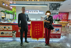 星藝裝飾項目經理周曉柒與客戶贈送錦旗合影